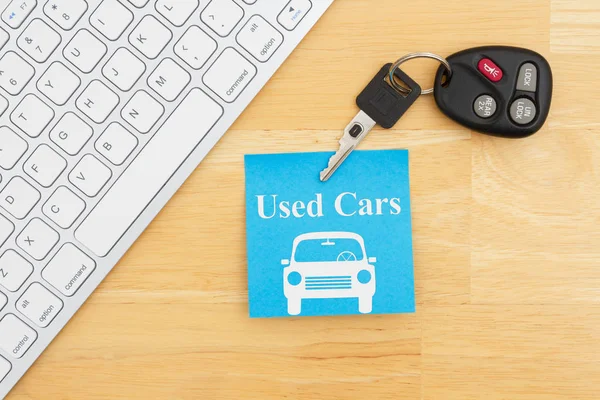 Gebruikt auto bericht met autosleutels met een toetsenbord op een kleverige nota — Stockfoto