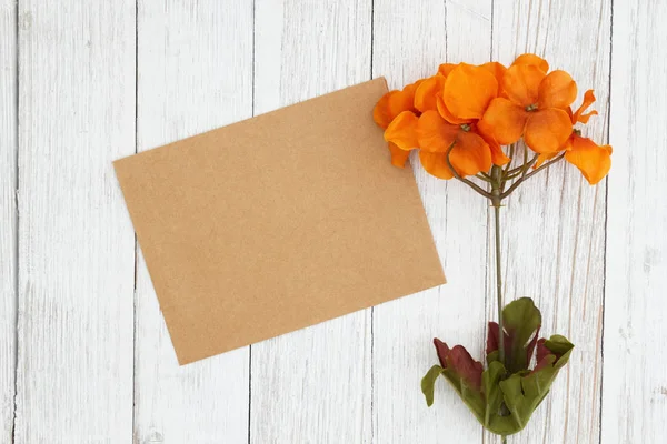 Flores de otoño anaranjadas y rojas con tarjeta de felicitación en blanco en weathere —  Fotos de Stock