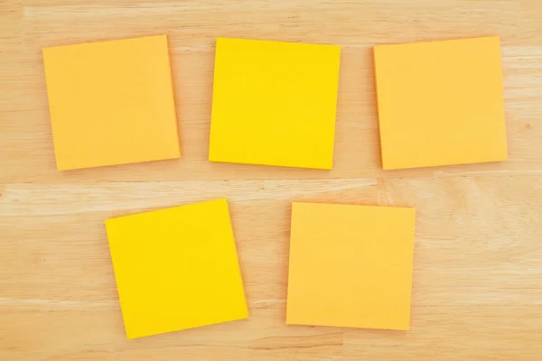 Five blank sticky notes on textured desk wood background — Stock Photo, Image