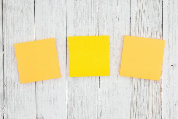 Three blank sticky notes on weathered whitewash textured wood ba — Stock Photo, Image