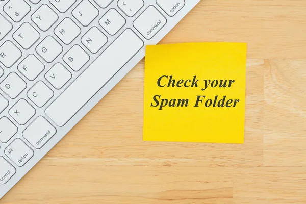 Compruebe el texto de su carpeta de spam en una nota adhesiva con un teclado —  Fotos de Stock