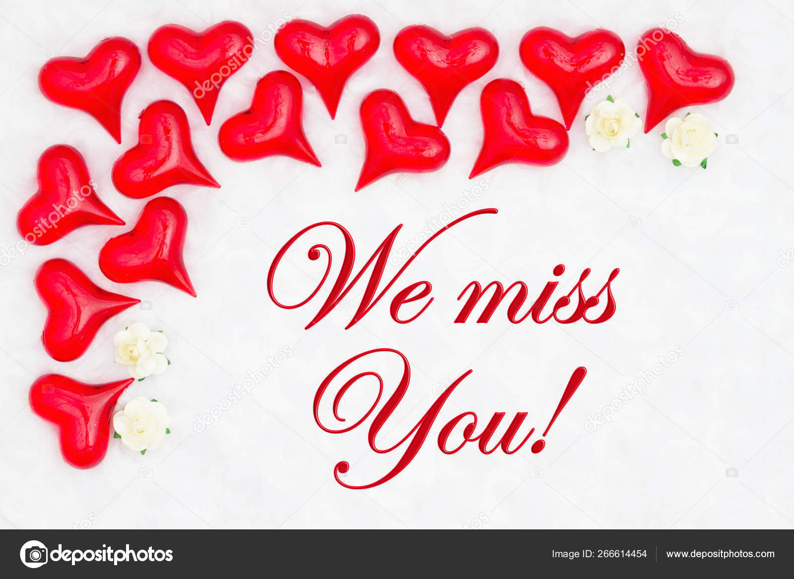 We miss you message with red hearts on white fabric Stock Photo by