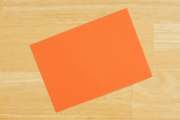 Πορτοκαλί κενή ευχετήρια κάρτα στο φόντο ξύλου με υφή — Φωτογραφία Αρχείου