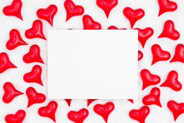 Tarjeta de felicitación blanca con corazones rojos sobre fondo de tela blanca —  Fotos de Stock