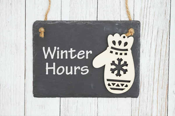 Holiday hours sign on chalkboard with mitten — Stock Photo, Image