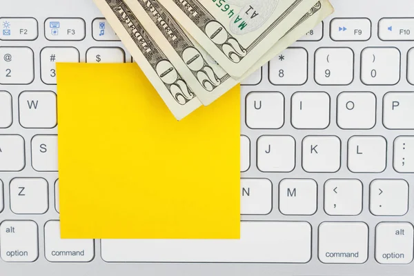 Geld auf einer Tastatur mit Haftnotiz — Stockfoto