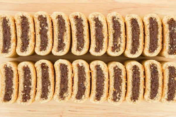 Fig cookies in a row on a wood table — Stock Photo, Image