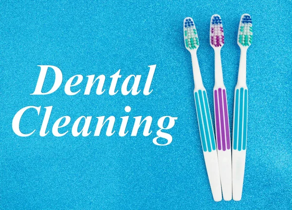 Dental cleaning text with toothbrushes — Stock Photo, Image