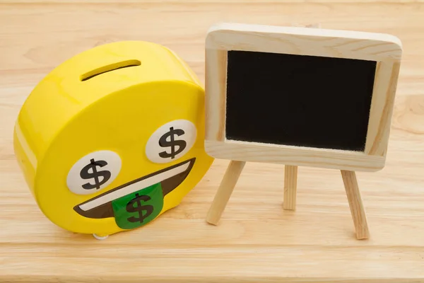 A coin bank on a desk with chalkboard — Stock Photo, Image