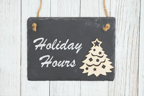 Holiday hours sign on chalkboard with Christmas tree — Stock Photo, Image