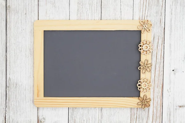 Blank chalkboard with flowers on weathered whitewash textured wo — Stock Photo, Image