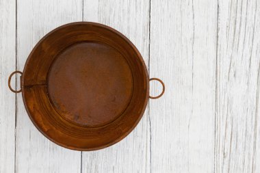 Yıpranmış badana dokulu ahşap arka plan üzerinde paslı teneke kova