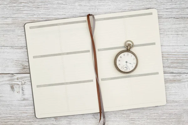 Planificador de día marrón en blanco con reloj de bolsillo en un blanco envejecido — Foto de Stock