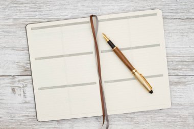 Bir yıpranmış badana ahşap b kalem ile Boş kahverengi gün planlayıcısı