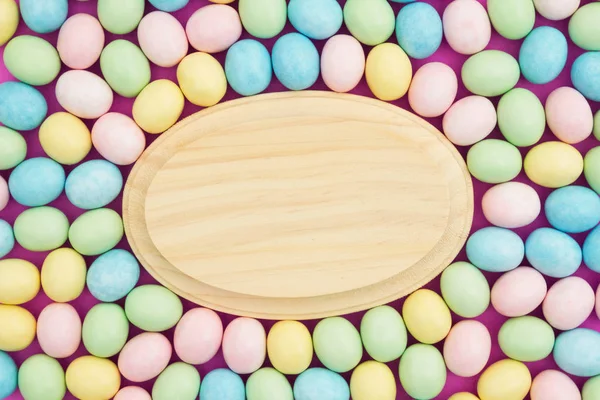 Candy påsk ägg bakgrund med trä skylt — Stockfoto