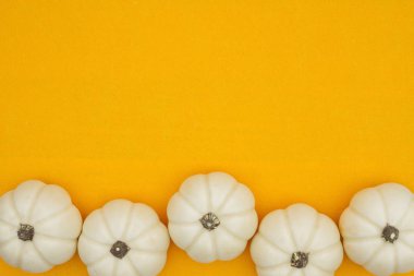 Turuncu üzerine beyaz balkabakları dokunmuş malzeme arka planı