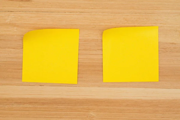 Duas notas pegajosas em branco sobre fundo de madeira de mesa texturizada — Fotografia de Stock