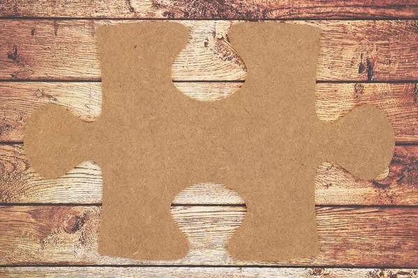 Brown blank cardboard puzzle piece on weathered  gunge textured