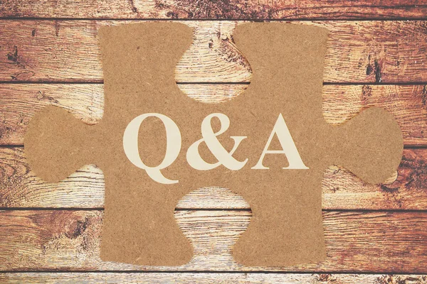 Q & A message on brown cardboard puzzle piece — стоковое фото