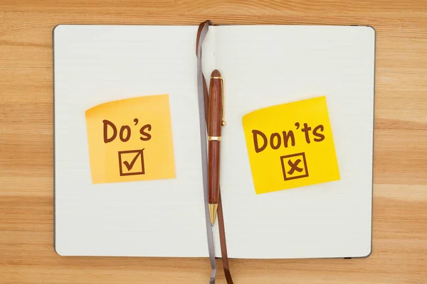 Do και Don 'ts σε δύο αυτοκόλλητα σημειώματα σε ένα ημερολόγιο με στυλό — Φωτογραφία Αρχείου