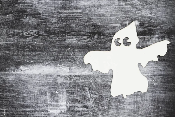 White ghost on weathered black grunge wood textured background — Stock Photo, Image