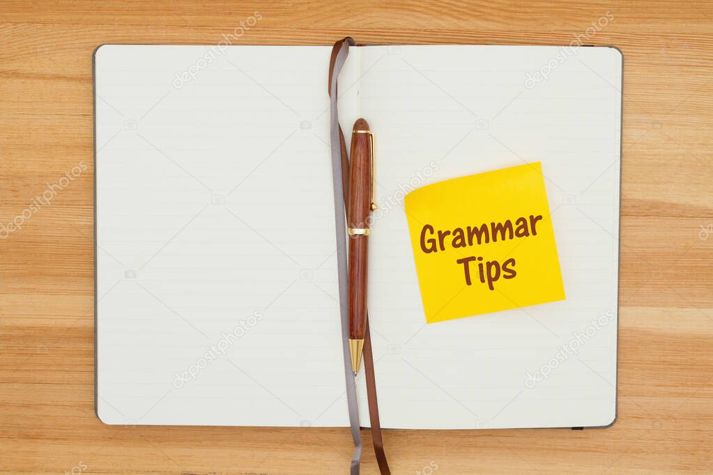 Grammar tips message on sticky note in a journal with a pen