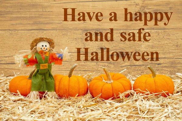 Feliz mensaje de Halloween con espantapájaros y calabazas naranjas en st —  Fotos de Stock