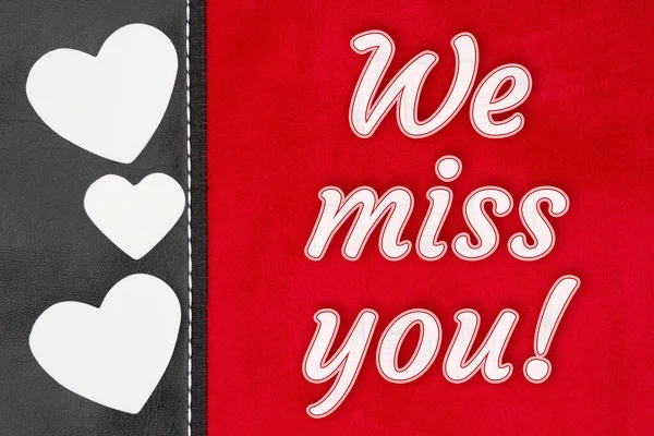 We miss you type message on red plush material with black leather side and hearts