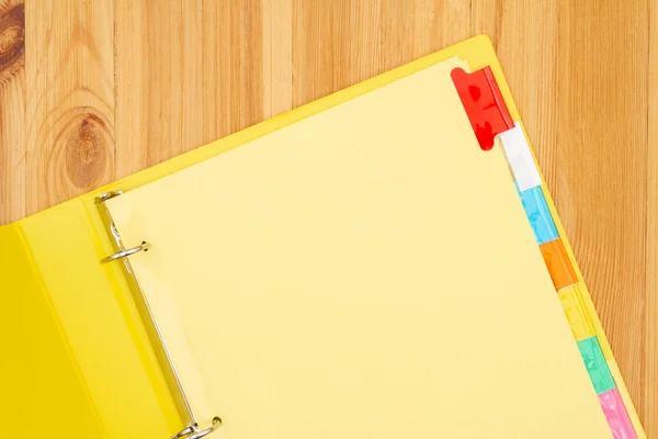 あなたの学校やビジネスメッセージのためのコピースペースと木製の机のモックアップの黄色のバインダーの空のファイルタブ — ストック写真