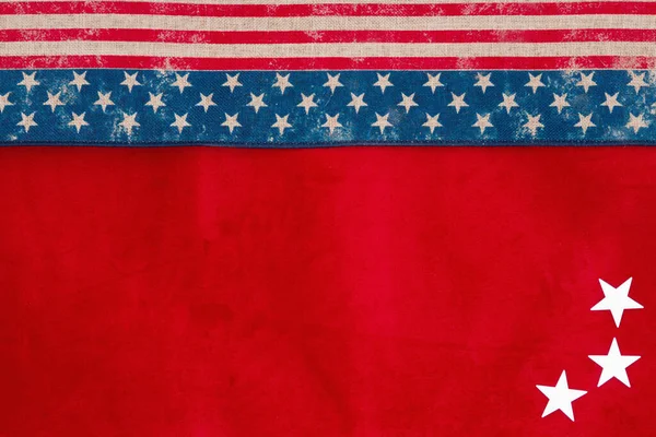 Retro USA stars and stripes burlap ribbon on red fabric background with copy space for your American message