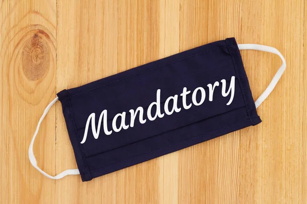 Mandatory Word Message Blue Cloth Face Mask Wood Desk Για Royalty Free Εικόνες Αρχείου