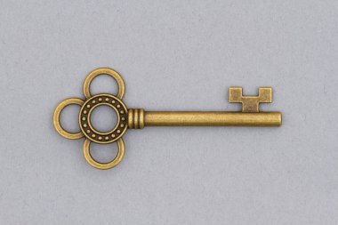 Eski model bronz yıpranmış ve yıpranmış iskelet anahtarı gri renkte izole edilmiş.