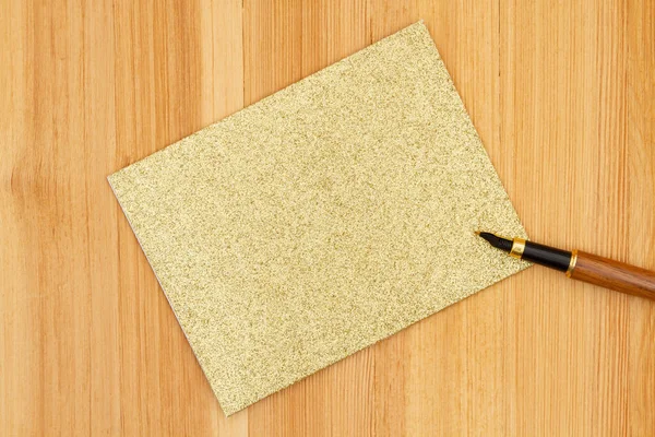 Blank Złota Błyszczące Teksturowana Kartka Życzeniami Długopisem Biurku — Zdjęcie stockowe