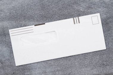 Yıpranmış gri bir taşın üzerinde, gecikmiş ya da acil durum mesajınız için fotokopi alanı olan boş bir iş zarfı.