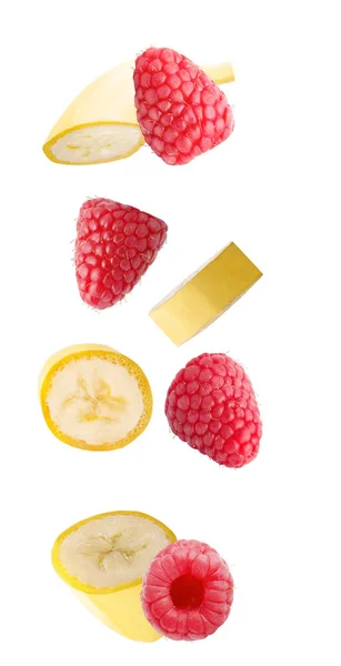 Isolated flying fruits. Falling banana and raspberry fruits isolated on white background with clipping path as package design element and advertising.