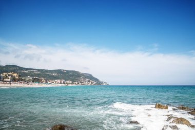 Arka planda çakıl taşı plajı ve mavi gökyüzü