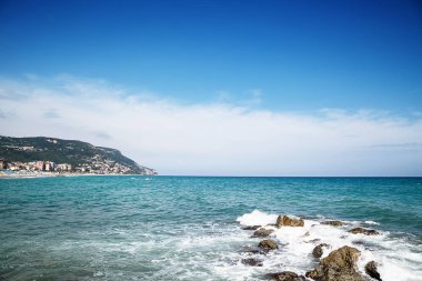 Arka planda çakıl taşı plajı ve mavi gökyüzü