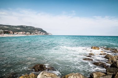 Arka planda çakıl taşı plajı ve mavi gökyüzü