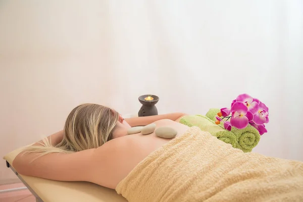 Junge Frau mit geschlossenen Augen bei einer Massage im Wellnesszentrum — Stockfoto