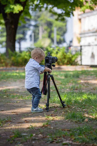 Dwa Lata Stary Chłopiec Jest Fotografem Dziecko Posiada Kamerę Statywie — Zdjęcie stockowe