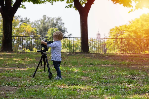 Dwa Lata Stary Chłopiec Jest Fotografem Dziecko Posiada Kamerę Statywie — Zdjęcie stockowe