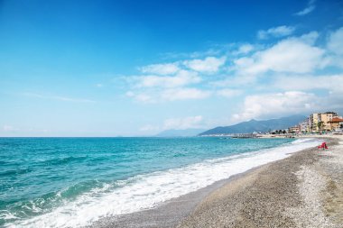 Arka planda çakıl taşı plajı ve mavi gökyüzü