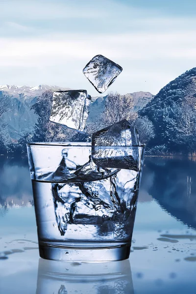 用冰把水倒进玻璃里, 反对自然景观 — 图库照片