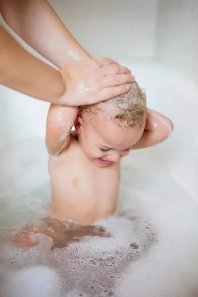 Cute two year old boy taking a relaxing bath with foam — Stock Photo, Image