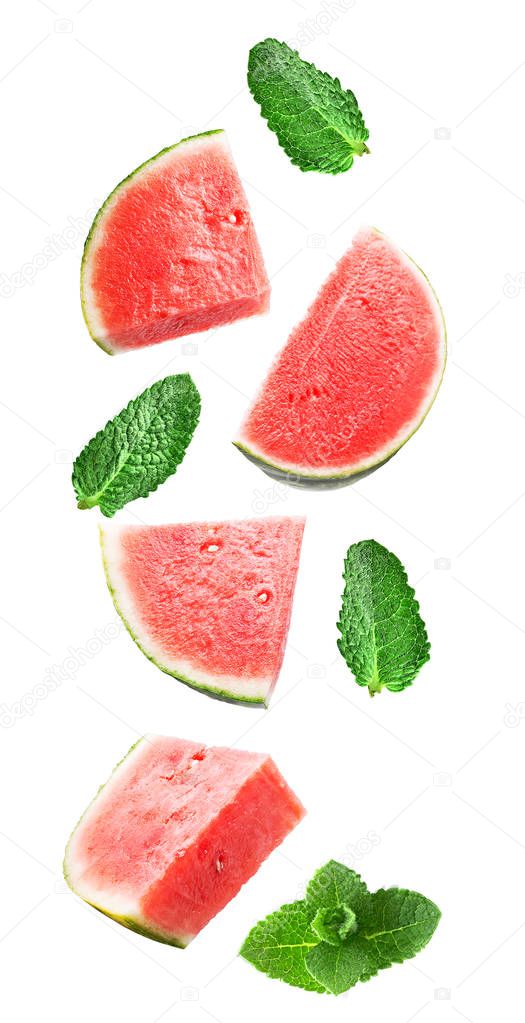 Flying fresh watermelon slices and mint leaves isolated on white background with clipping path as package design element and advertising. Full depth of field.