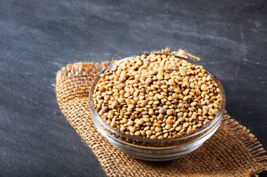 Raw lentils on balck stone background. Healthy vegetarian food concept. Superfoods. Copy space. Lentils are rich in complex carbohydrates, fiber, high in protein and make an excellent meat alternative. clipart