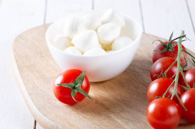 Organik kiraz domates ve mozzarella beyaz zemin üzerine seramik plaka. Üstten görünüm. Yat. yumuşak odak.