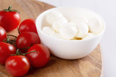 Organik kiraz domates ve mozzarella beyaz zemin üzerine seramik plaka. Üstten görünüm. Yat. yumuşak odak.