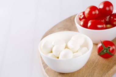 Organik kiraz domates ve mozzarella beyaz zemin üzerine seramik plaka. Üstten görünüm. Yat. yumuşak odak.