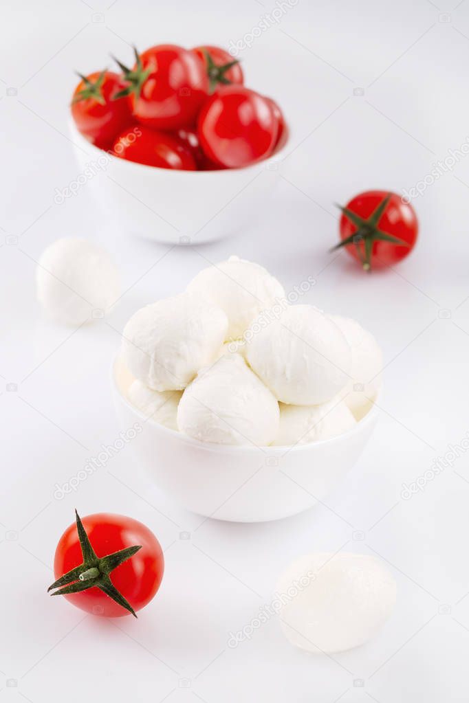 Fresh cherry tomatoes and mozzarella on white background